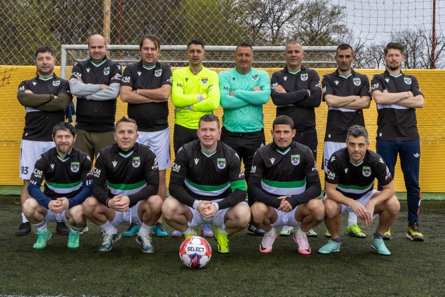 Echipa United Brașov, în echipament negru cu dungi verzi și albe, la fotografia de grup pe terenul de minifotbal